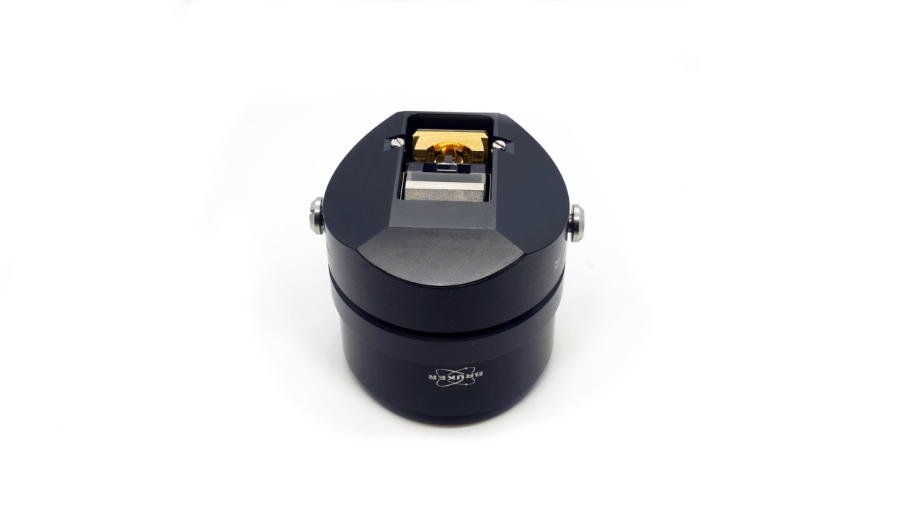 Lente objetiva para microscópio FT-IR. Corpo preto e espelhos dourados. É usado para pastagem de medidas de incidência.